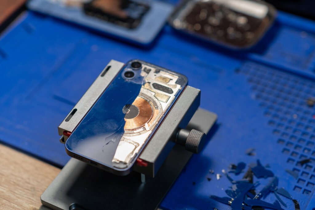 Phone Back Glass Fix, Depicts a skilled technician replacing the back glass of a smartphone in a clean, professional service center. Perfect for mobile repair promotions